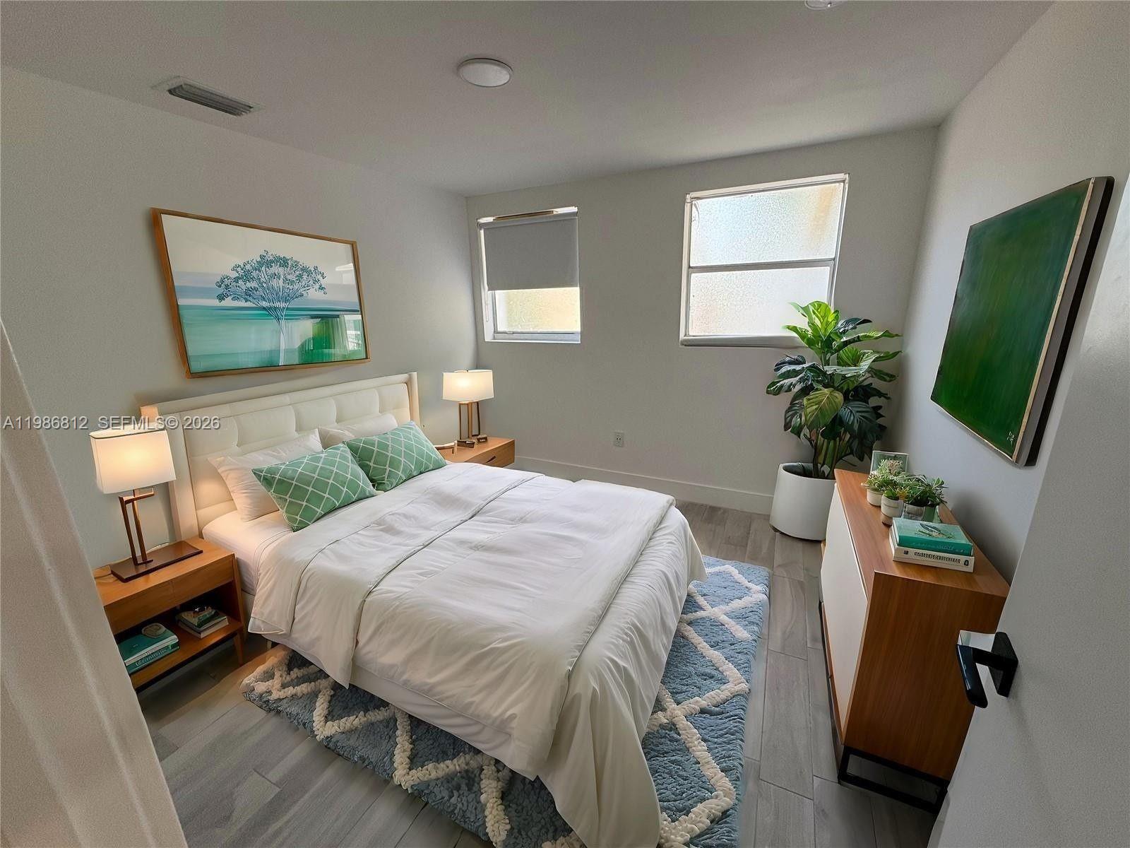 A bedroom features a white bed, two nightstands, a blue patterned rug, and a dresser — 1000 7th St # 10, Miami Beach FL 33139, MIAMI BEACH, FL