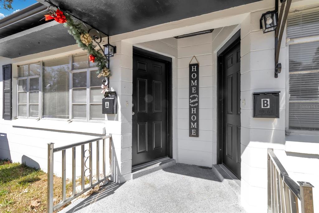 The exterior entrance features two black doors labeled A and B with a hanging sign — 307 E MONUMENT AVENUE UNIT A, KISSIMMEE, FL