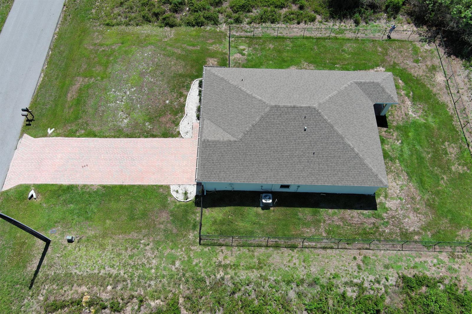 An aerial view shows a house with a brick driveway and a fenced backyard — 113 Plantation Drive, FL 33935, FL
