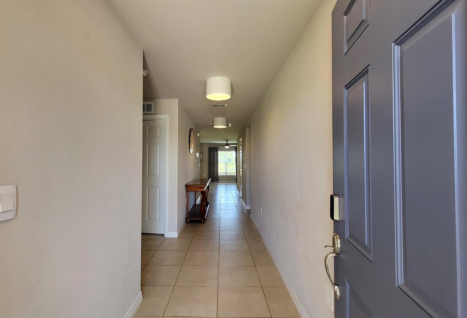 A view from an open front door looking down a long, tiled hallway — 113 Plantation Drive, FL 33935, FL