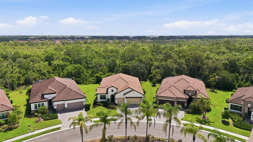 An aerial view shows a suburban house with a red tile roof and a red pin — 13231 INDIGO WAY, BRADENTON, FL