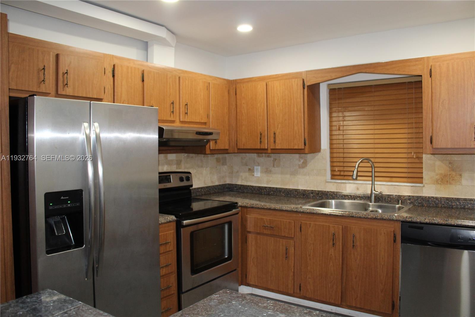 A kitchen features wood cabinets, stainless steel appliances, a tile backsplash, and granite countertops — 5140 SW 40th Ave # 3C, Dania Beach FL 33314, DANIA BEACH, FL