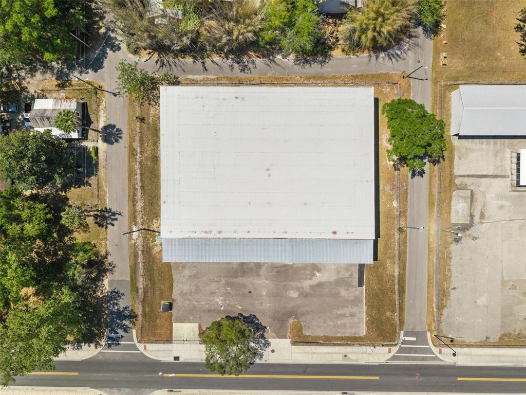An aerial view shows a rectangular building with a metal roof and an adjacent parking lot — 1030 SE 4TH STREET, GAINESVILLE, FL