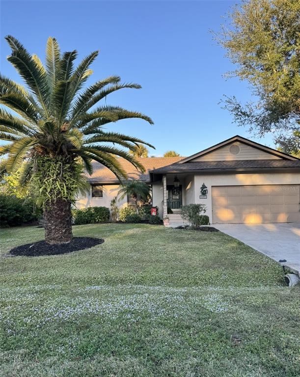 A single-story house with a large palm tree, a two-car garage, and a front lawn — 4487 TRAILS DRIVE, SARASOTA, FL