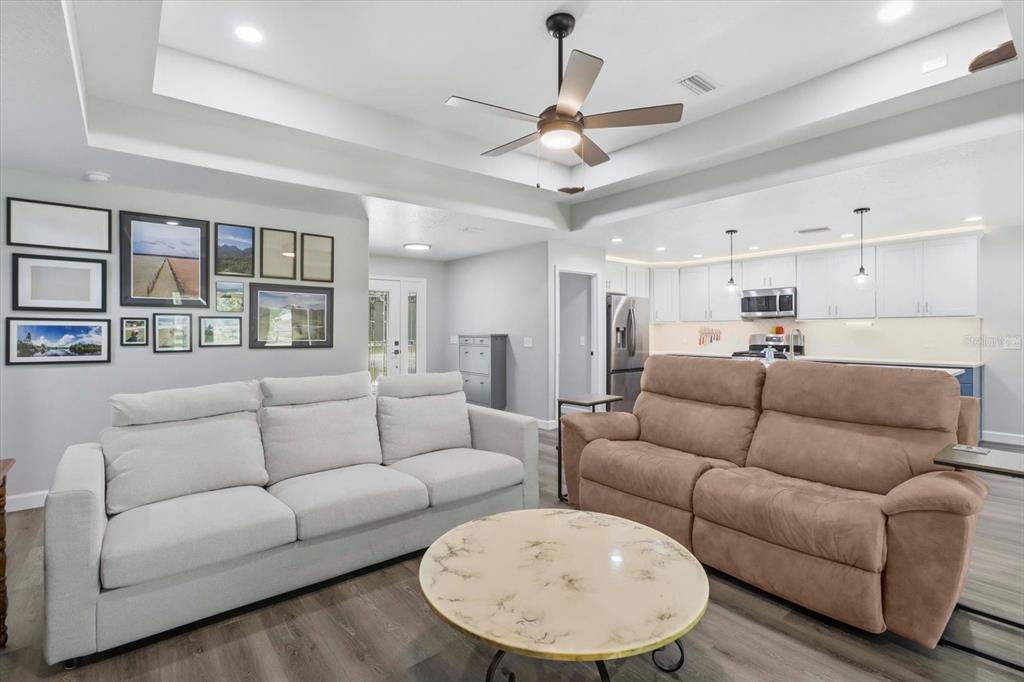 A living room with a white sofa, brown recliner, round coffee table, and gallery wall — 232 E FALCON STREET, DUNNELLON, FL