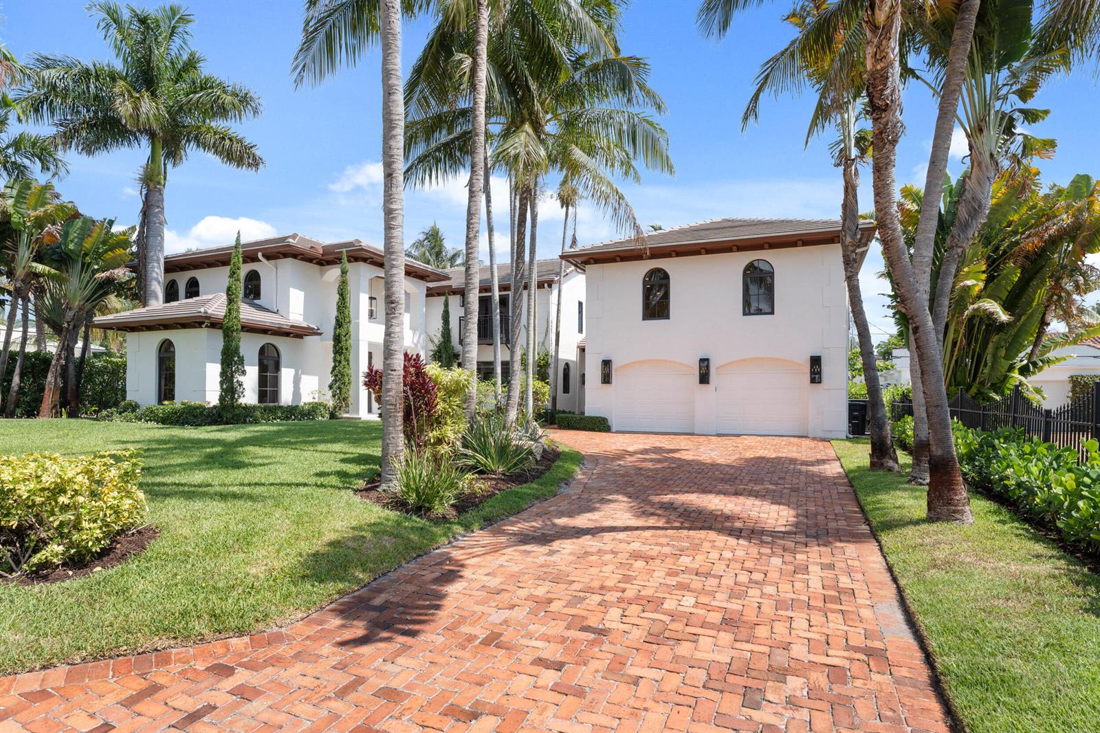 A two-story white house with a brick driveway and palm trees in the front yard — 257 E Lakewood Road, West Palm Beach FL 33405, WEST PALM BEACH, FL