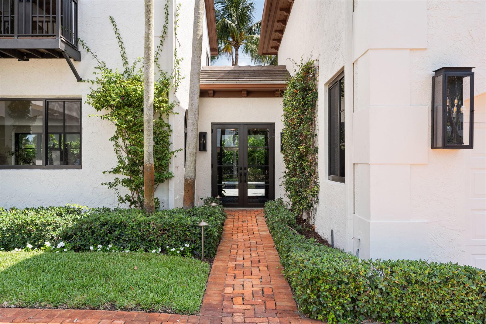 A brick walkway leads to the glass double front doors of a white stucco home — 257 E Lakewood Road, West Palm Beach FL 33405, WEST PALM BEACH, FL