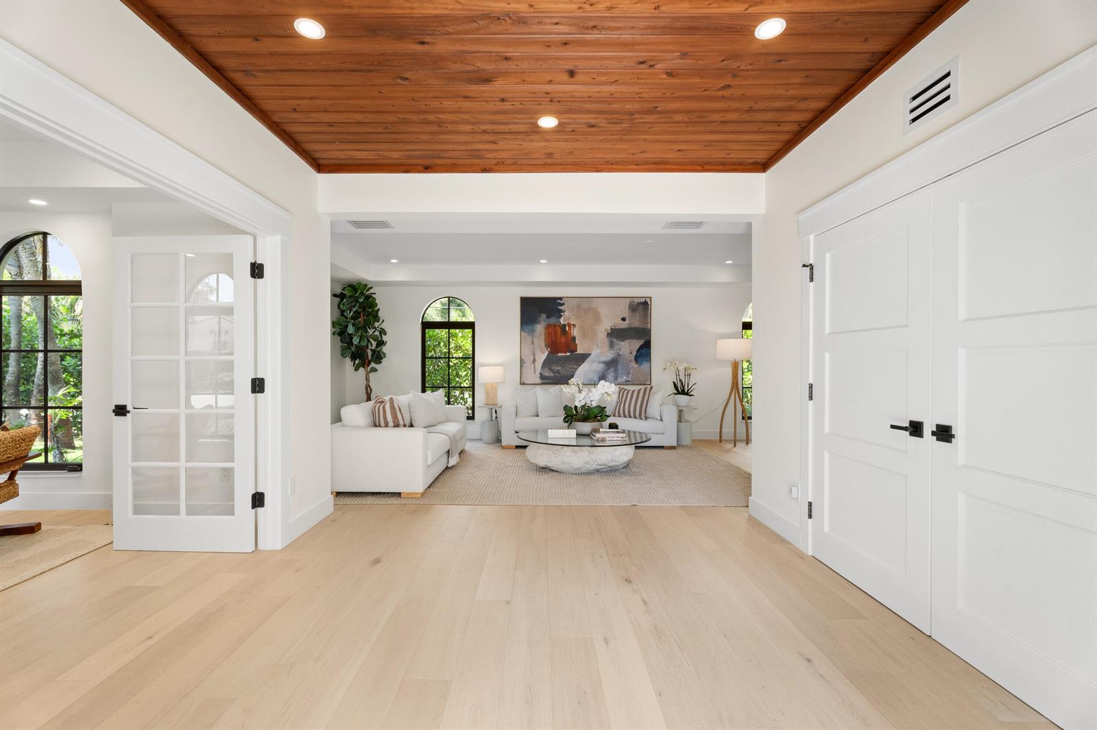 A bright, open living room features a wood-paneled ceiling, white walls, and light hardwood floors — 257 E Lakewood Road, West Palm Beach FL 33405, WEST PALM BEACH, FL