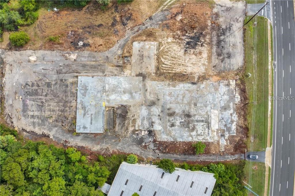 An aerial view shows a cleared lot with a concrete building foundation and surrounding vegetation — 3131 US HIGHWAY 441 / 27, FRUITLAND PARK, FL