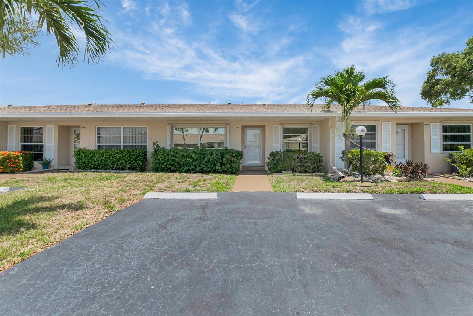 A single-story residential building with a tan facade, a front walkway, and a parking lot — 8829 Bella Vista Drive # 282, Boca Raton FL 33433, BOCA RATON, FL