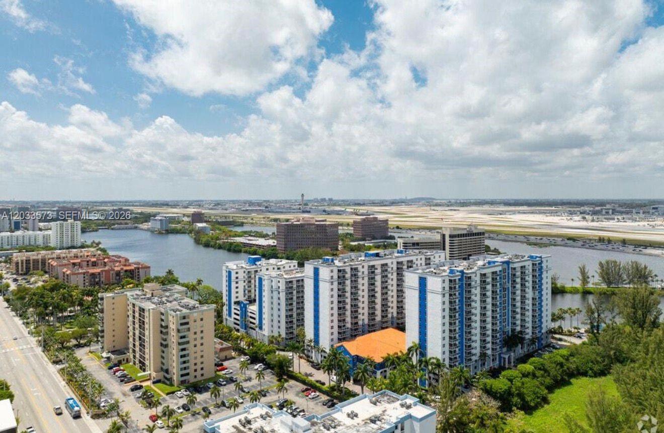 An aerial view shows a large apartment complex situated next to a lake and airport — 5091 NW 7th St # 906, Miami FL 33126, MIAMI, FL