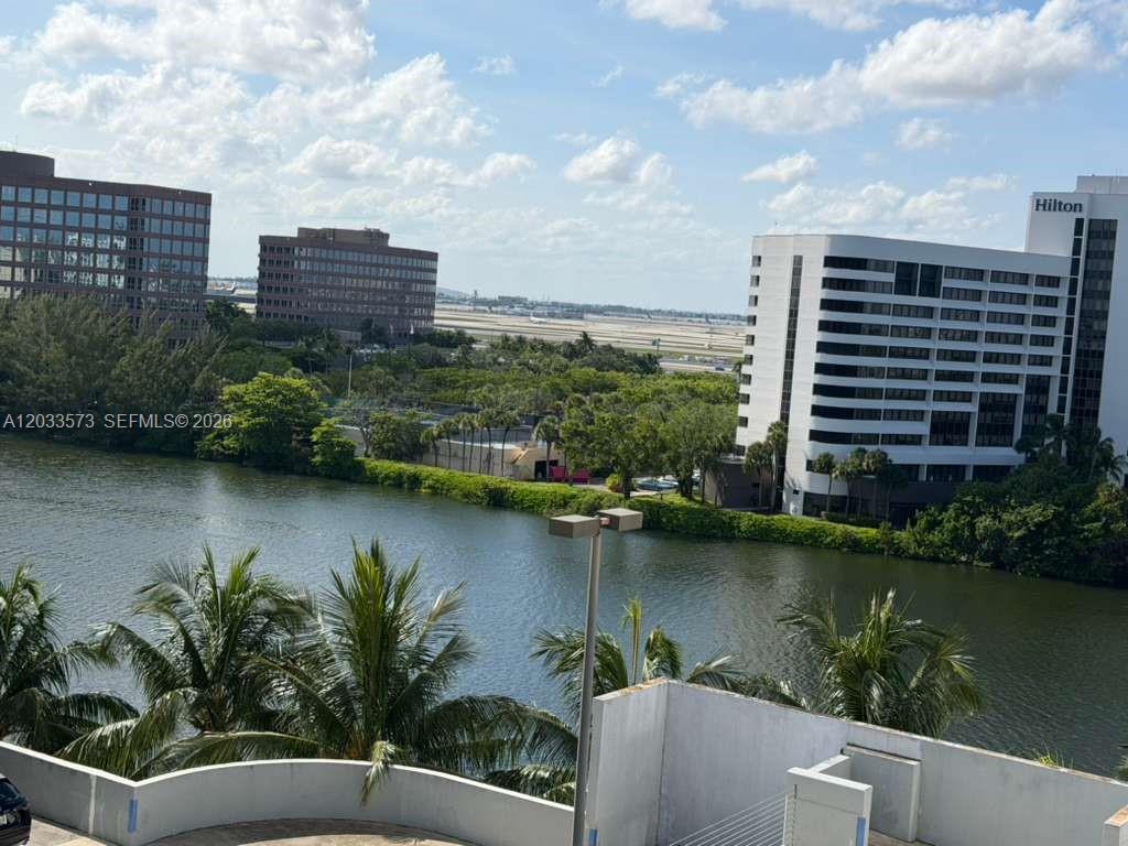 An elevated view shows a canal, palm trees, office buildings, and a Hilton hotel — 5091 NW 7th St # 906, Miami FL 33126, MIAMI, FL