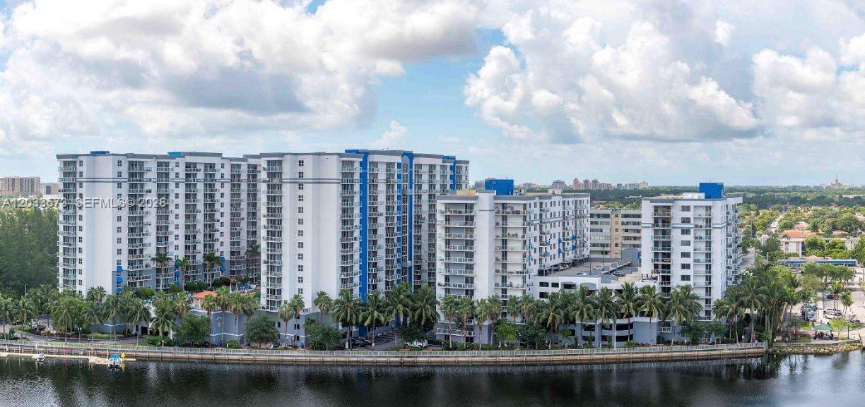 An aerial view of a large multi-story apartment complex situated along a waterfront — 5091 NW 7th St # 906, Miami FL 33126, MIAMI, FL
