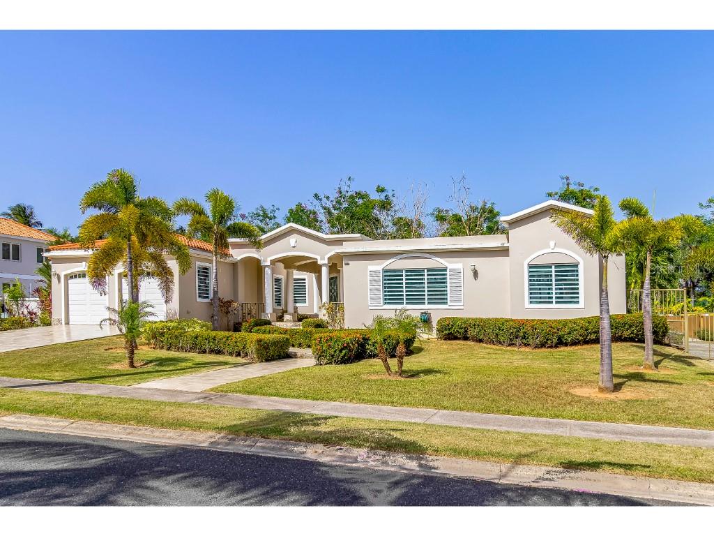 A single-story beige house with a tiled roof, palm trees, and a manicured front lawn — A3 PASEO MADRID, VEGA ALTA, PR