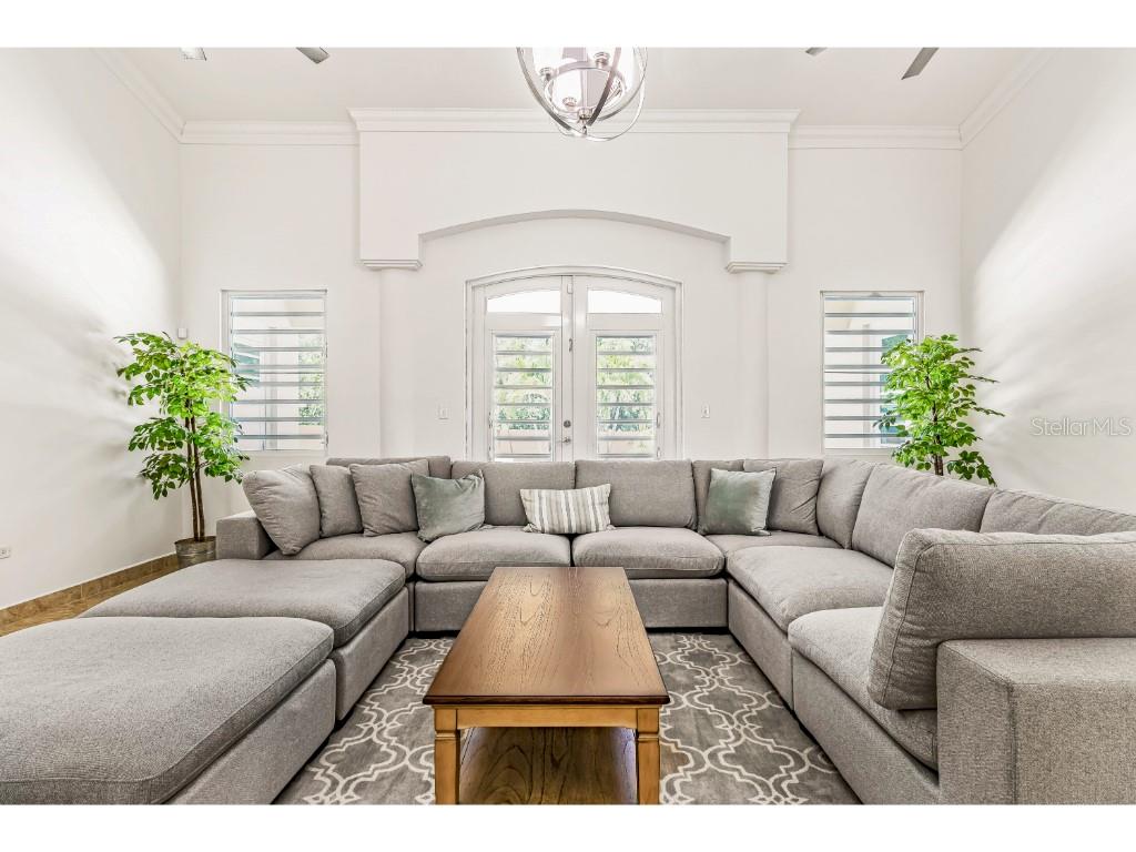 A living room features a large gray sectional sofa, a wooden coffee table, and French doors — A3 PASEO MADRID, VEGA ALTA, PR
