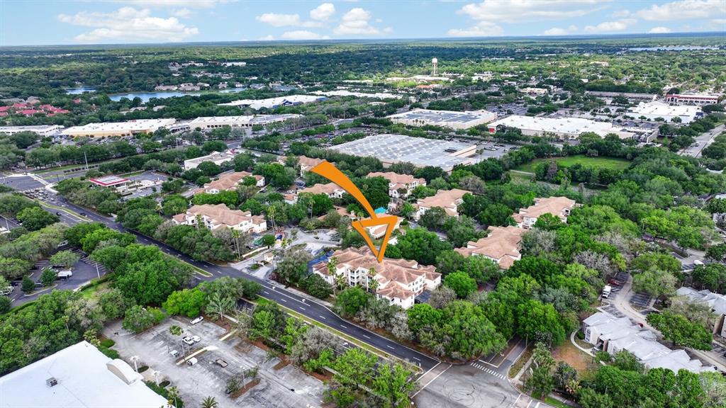 An aerial view shows a multi-story apartment building surrounded by trees and parking lots — 832 CAMARGO WAY UNIT 306, ALTAMONTE SPRINGS, FL