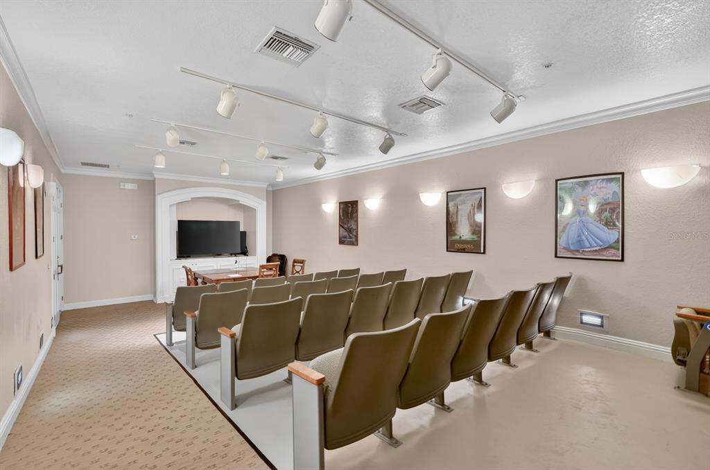 A home theater room features rows of tan chairs, a television, and wall-mounted lighting — 832 CAMARGO WAY UNIT 306, ALTAMONTE SPRINGS, FL