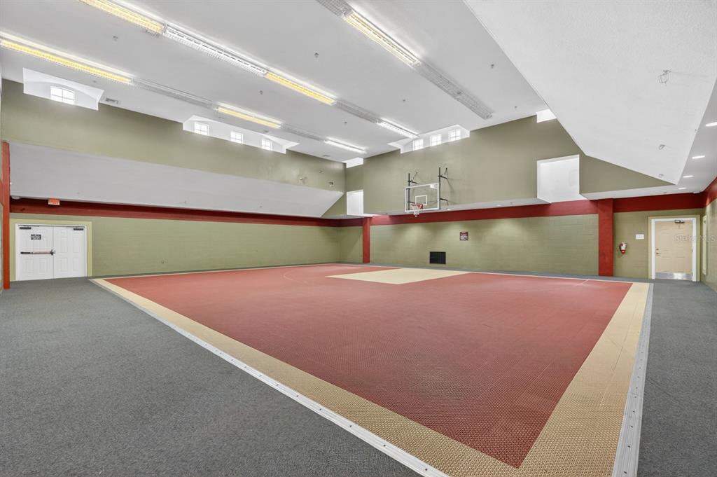 An indoor basketball court with a red and beige floor, green walls, and overhead lighting — 832 CAMARGO WAY UNIT 306, ALTAMONTE SPRINGS, FL