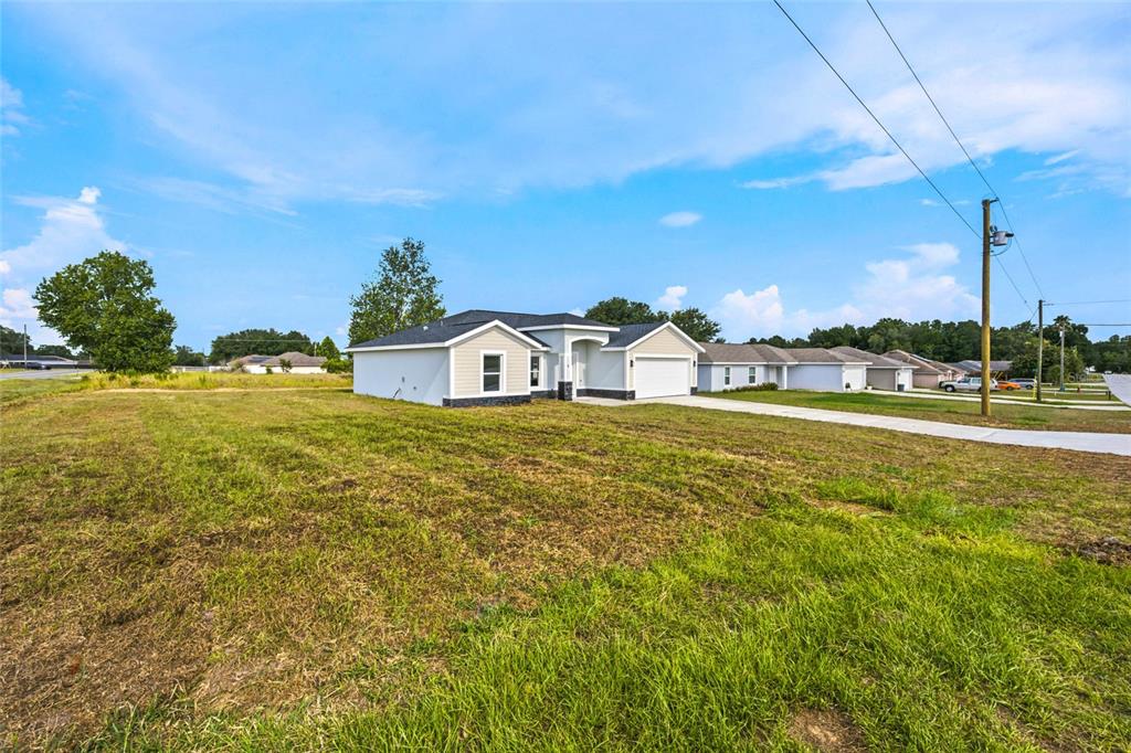 A single-story suburban house with a white exterior and a two-car garage — 1 DOGWOOD DRIVE PASS, OCALA, FL