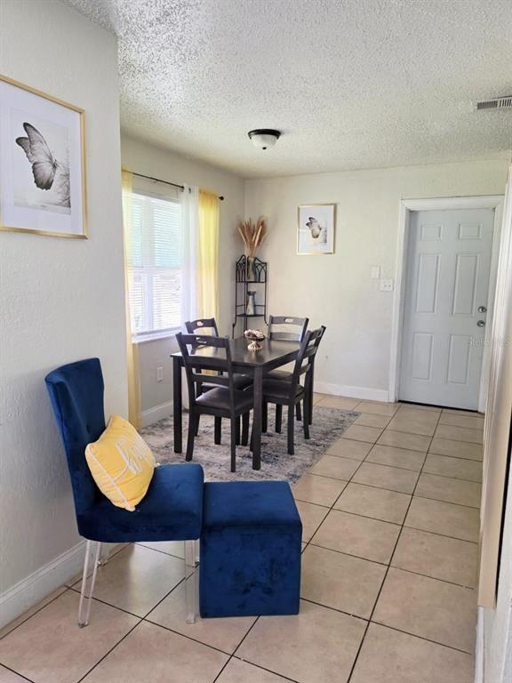 A dining area with a table, four chairs, and a blue velvet chair with ottoman — 2316 MISPAH AVENUE, LEESBURG, FL