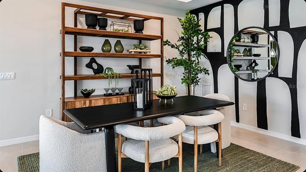 A dining room features a black table, four textured chairs, and a large wooden shelving unit — 5392 GUNWALE DRIVE, COCOA, FL