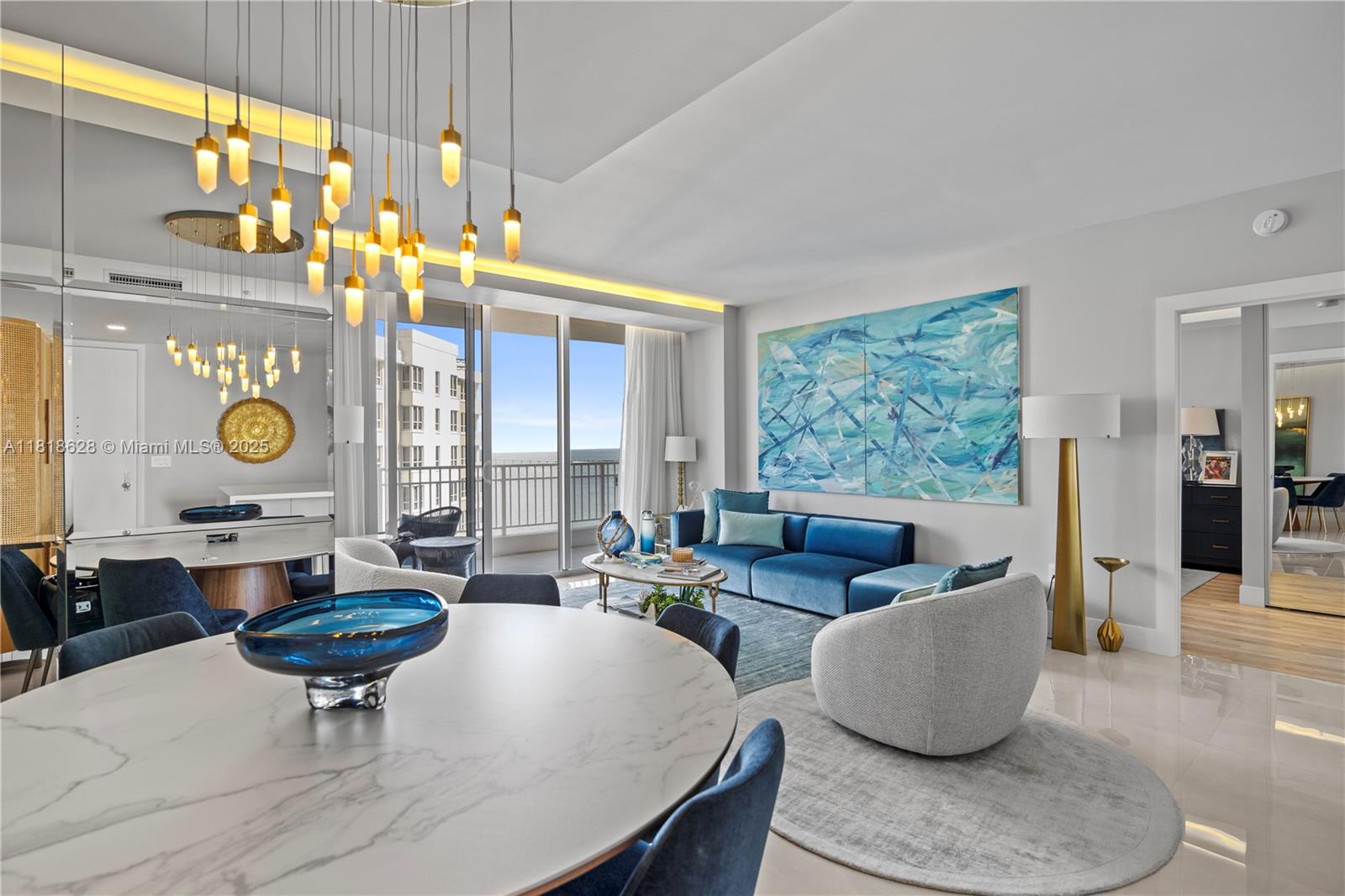 A modern living and dining area features a blue sofa, marble table, and pendant lighting — 801 Brickell Key Blvd # 2203, Miami FL 33131, MIAMI, FL