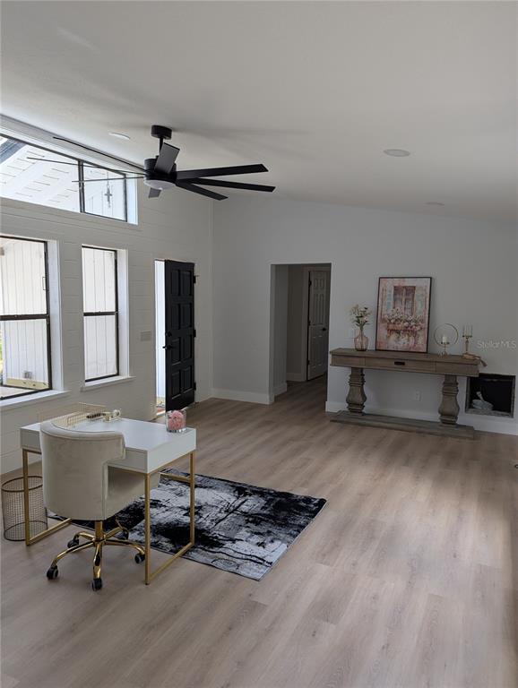 A bright room features light wood flooring, a white desk, a black ceiling fan, and windows — 4212 HOMEWOOD LANE, LAKELAND, FL
