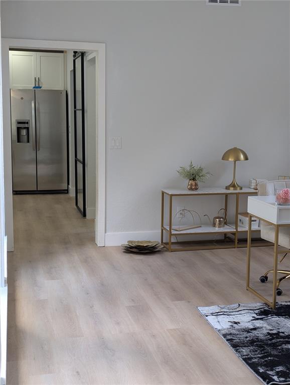 A room with light wood flooring features a console table and a desk near a doorway — 4212 HOMEWOOD LANE, LAKELAND, FL
