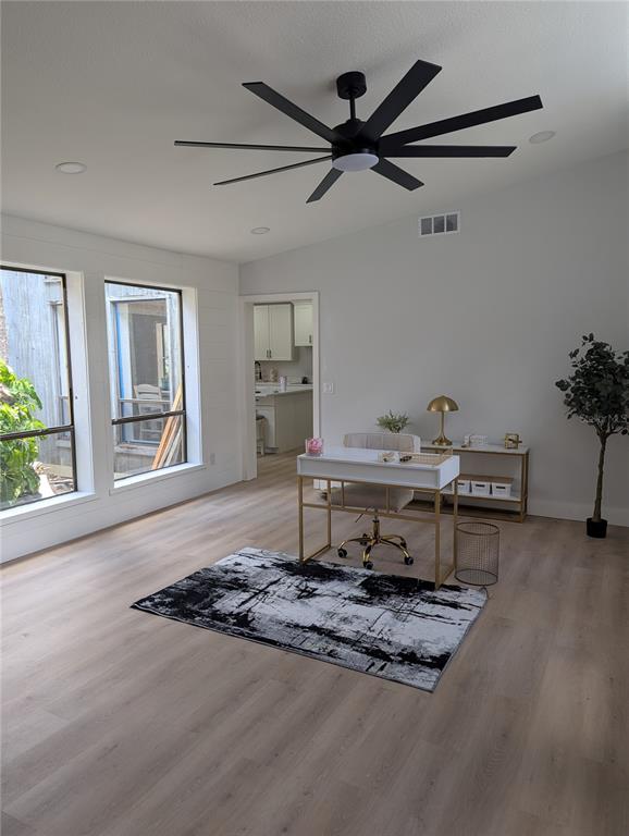 A bright home office features light wood flooring, a modern ceiling fan, and large windows — 4212 HOMEWOOD LANE, LAKELAND, FL