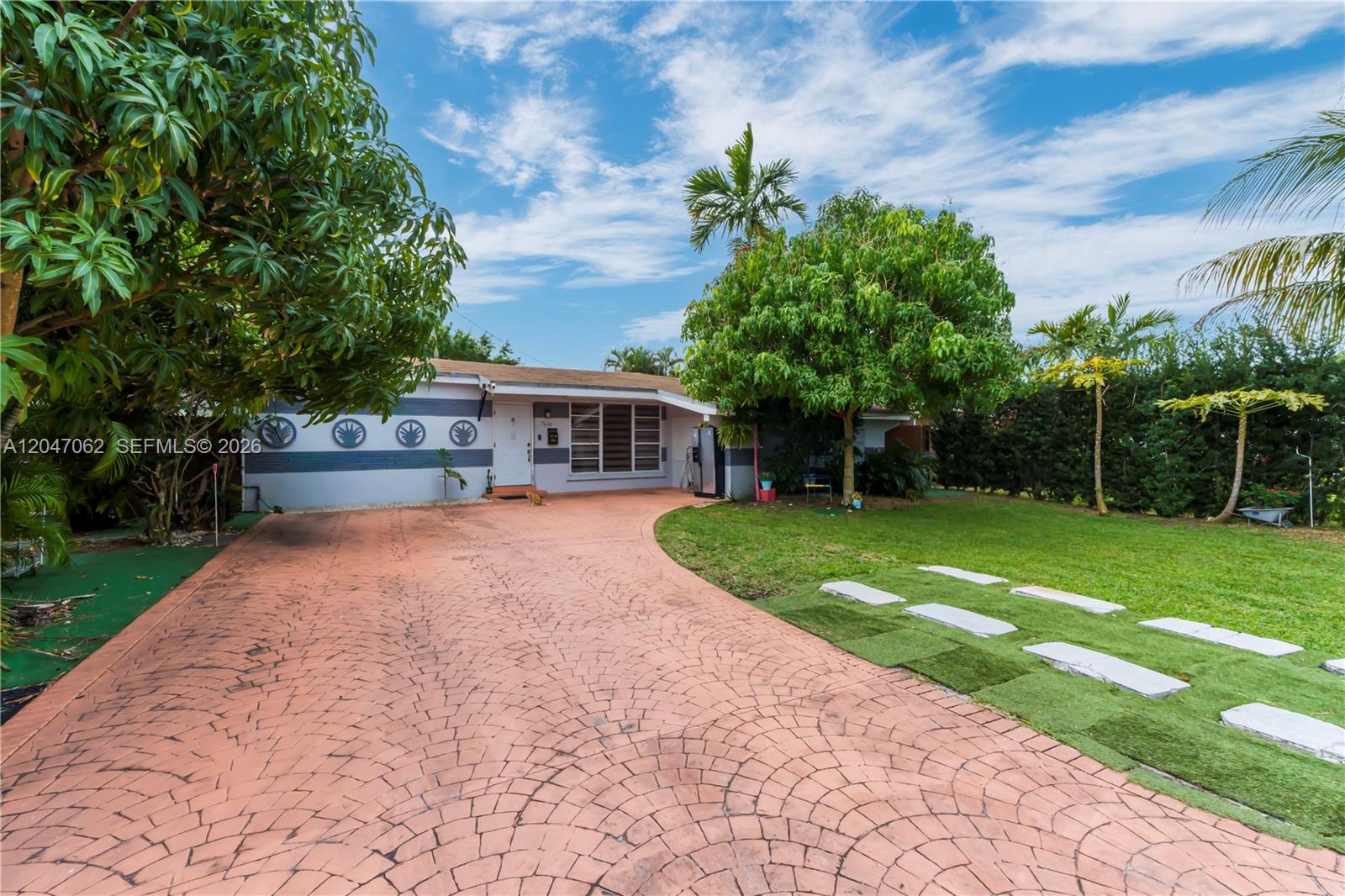 A single-story house features a stamped concrete driveway, a front lawn, and mature trees — 7630 Plantation Blvd, Miramar FL 33023, MIRAMAR, FL