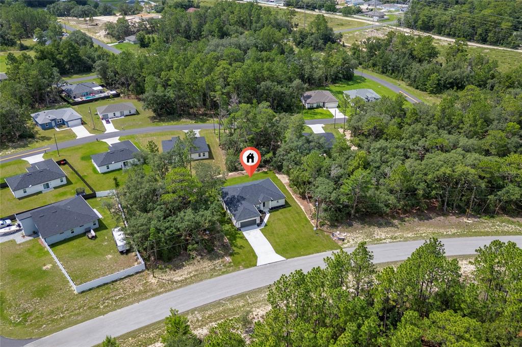 An aerial view shows a single-story house with a dark roof and a concrete driveway — 455 MARION OAKS PASS, OCALA, FL