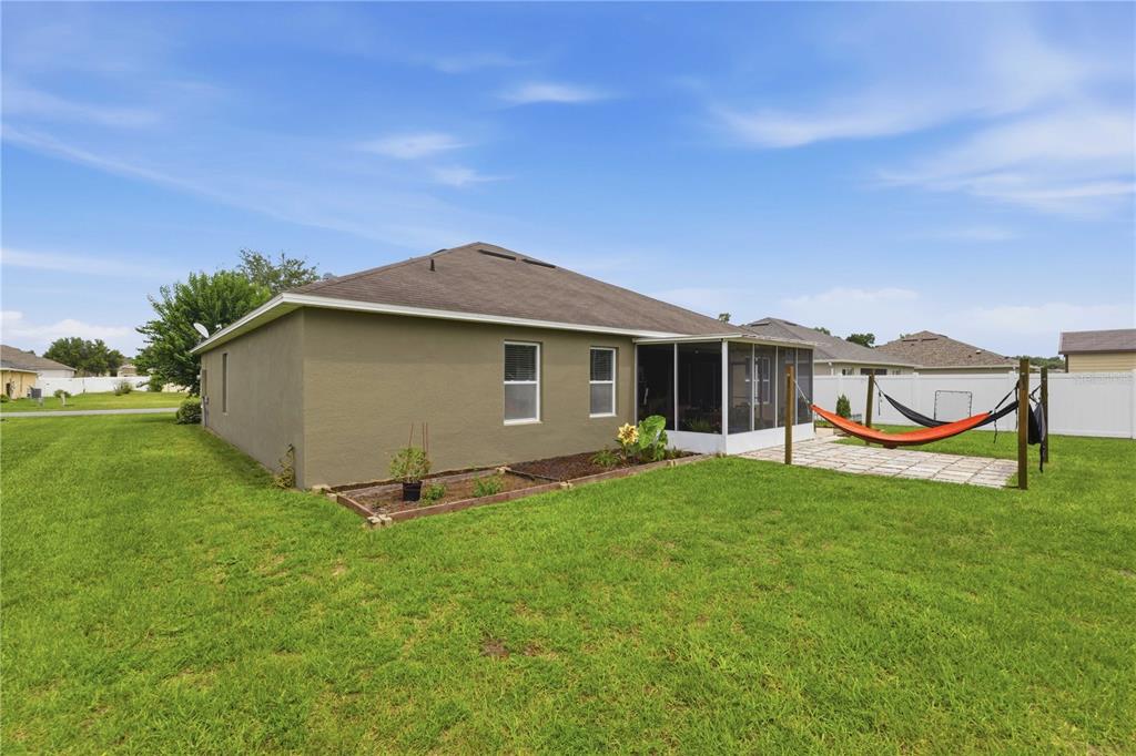 The exterior of a house with a screened-in porch, a hammock, and a grassy yard — 6824 SW 64TH TERRACE, OCALA, FL