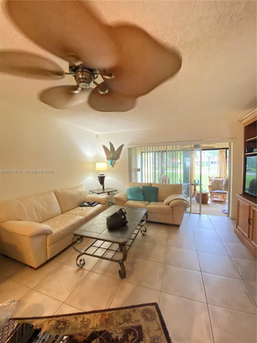 A living room features beige leather sofas, a metal coffee table, and tile flooring — 432 Bennington Ln # 432, Lake Worth FL 33467, LAKE WORTH, FL