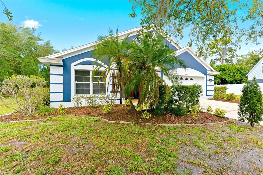 A blue single-story house with white trim, a palm tree, and a concrete driveway — 5976 48TH STREET E, BRADENTON, FL