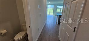 A view from a small bathroom looking out into a bright, open-concept living area — 2126 CRAPE JASMINE LANE, ORLANDO, FL