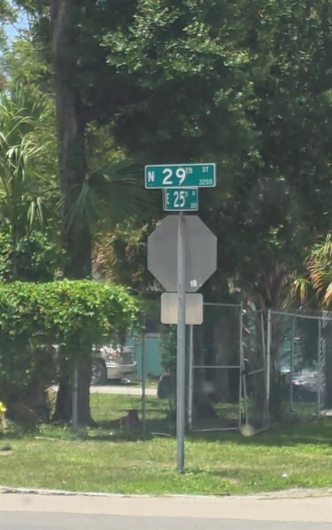 A street sign for North 29th Street and East 25th Avenue stands above a stop sign — 2919 E 25TH AVENUE, TAMPA, FL
