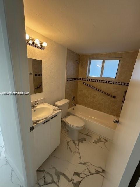 A bathroom features a white vanity, a toilet, and a bathtub with a grab bar — 661 W 81st St # 4, Hialeah FL 33014, HIALEAH, FL
