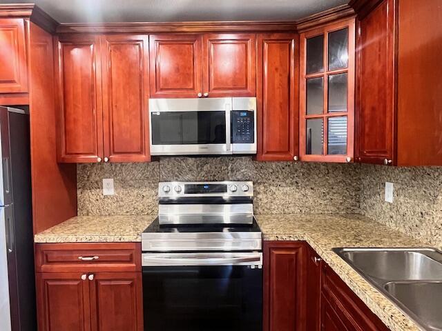 A kitchen features cherry wood cabinets, stainless steel appliances, and speckled granite countertops — 1679 NW 15th Vista, Boca Raton FL 33432, BOCA RATON, FL