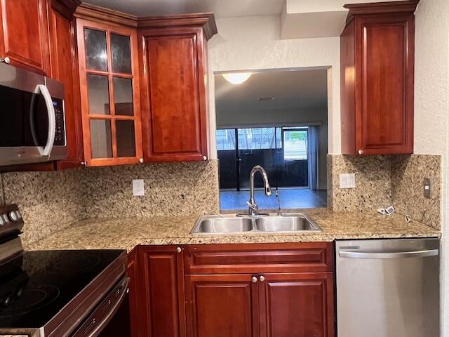 A kitchen features cherry wood cabinets, granite countertops, stainless steel appliances, and a pass-through window — 1679 NW 15th Vista, Boca Raton FL 33432, BOCA RATON, FL