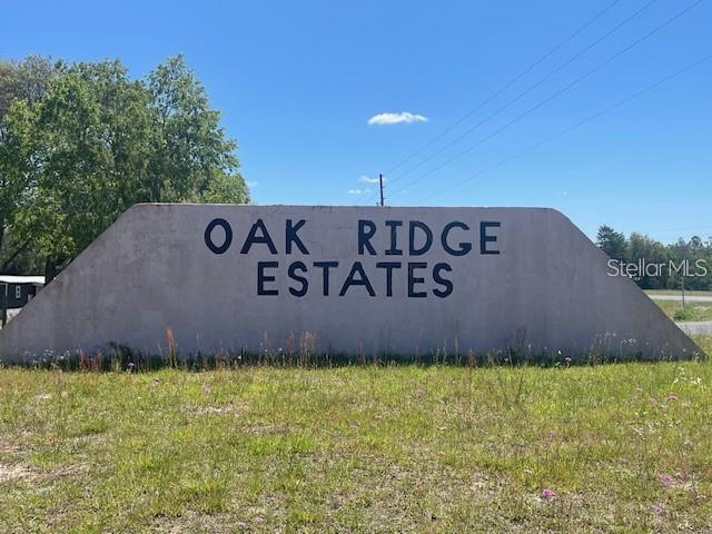 A large, trapezoidal concrete sign displays the words Oak Ridge Estates in a grassy field — 000 NE 68TH PLACE, WILLISTON, FL