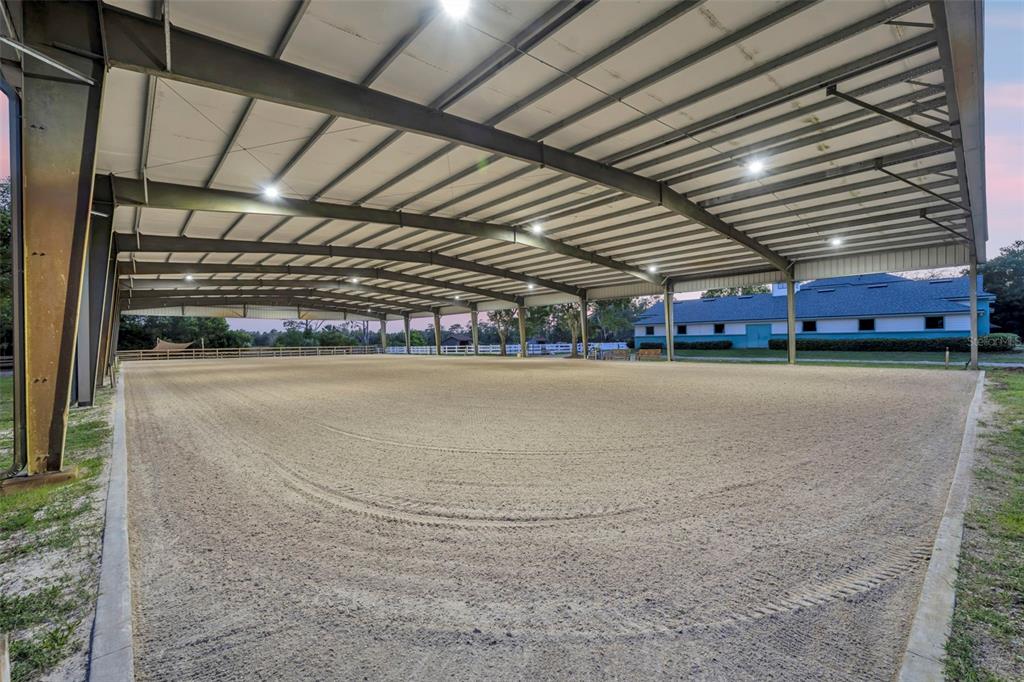 A large, open-air covered equestrian riding arena with a sand surface and metal roof — 3287 N COUNTY ROAD 426, GENEVA, FL