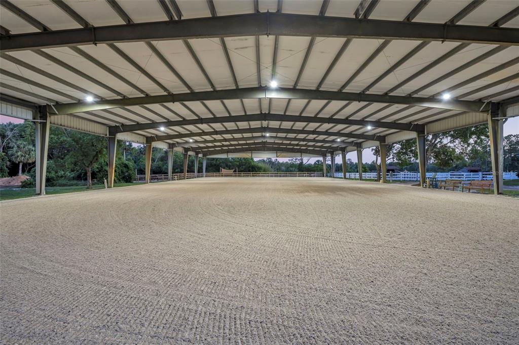 A large, open-air covered riding arena features a sand floor and metal support beams — 3287 N COUNTY ROAD 426, GENEVA, FL