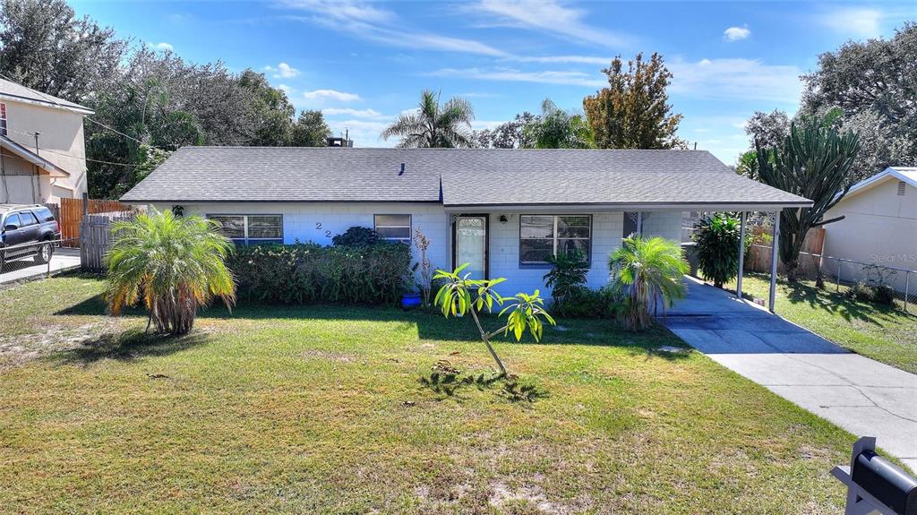 A single-story house with a white exterior, a gray shingled roof, and a front carport — 221 DOROTHY STREET, AUBURNDALE, FL