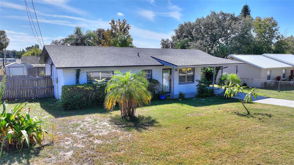 A single-story white house with a gray roof and a front carport sits on grass — 221 DOROTHY STREET, AUBURNDALE, FL