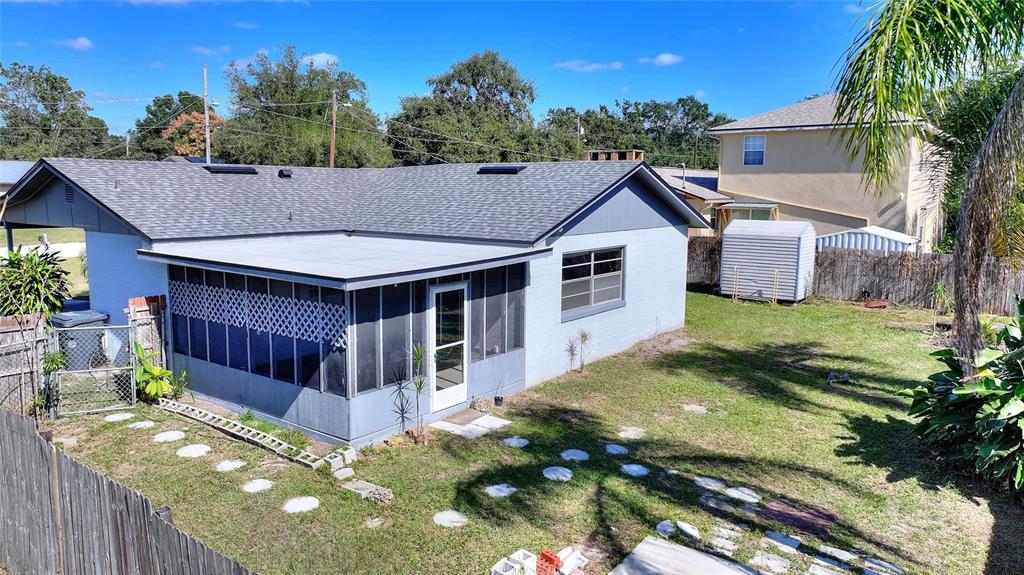 A light blue house with a screened-in porch and a gray shingled roof — 221 DOROTHY STREET, AUBURNDALE, FL