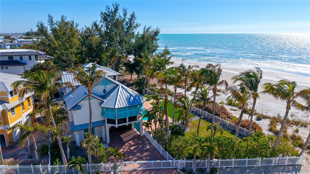 An aerial view shows a multi-story beach house with a metal roof and palm trees — 95 52ND STREET, HOLMES BEACH, FL