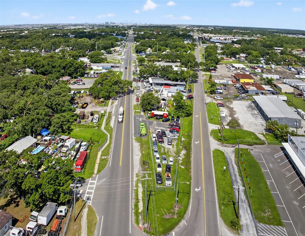 An aerial view shows a divided road with surrounding commercial properties, parking lots, and trees — 6220 E BROADWAY AVENUE, TAMPA, FL