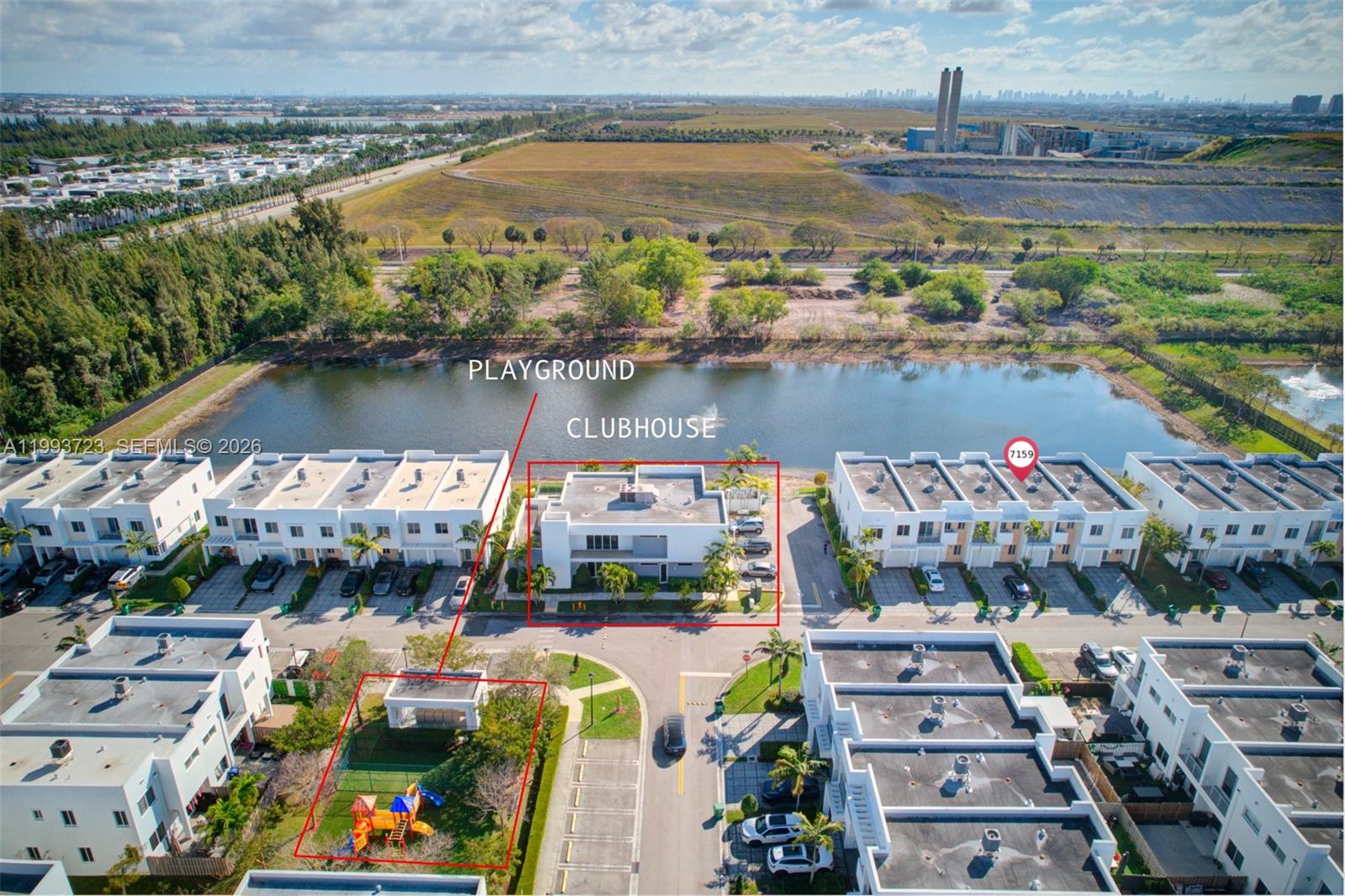 An aerial view shows a residential complex with a clubhouse, playground, and a lake — 7159 NW 102nd Place, Doral FL 33178, DORAL, FL