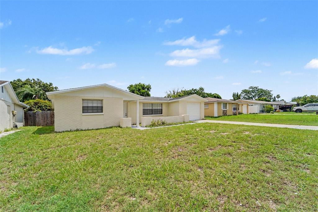 A single-story, light-colored brick house with a garage and a large front lawn — 5102 SCHOOL ROAD, NEW PORT RICHEY, FL