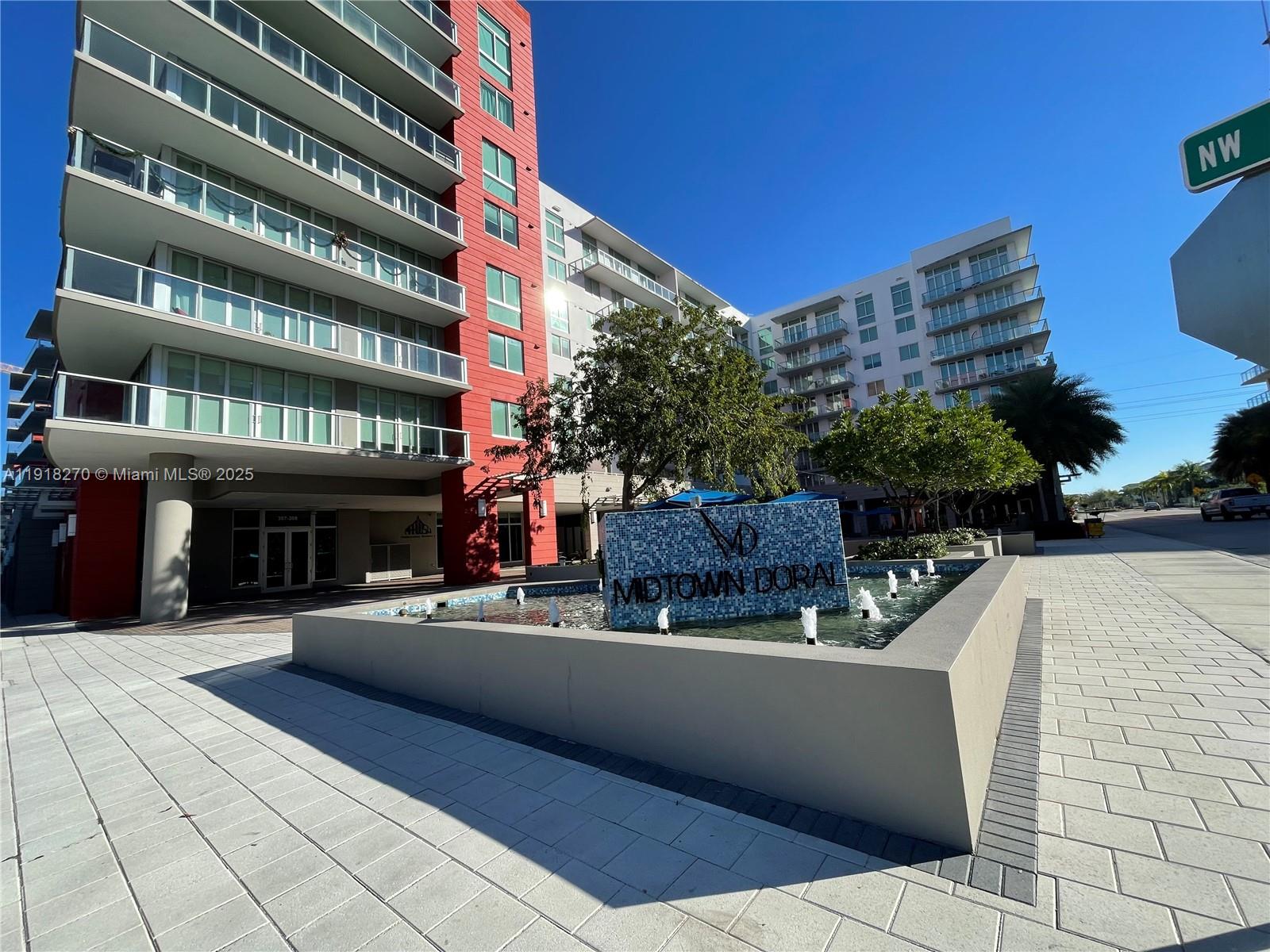 A modern apartment building features a blue tiled fountain with the name Midtown Doral — 7875 NW 107th Ave # 514, Doral FL 33178, DORAL, FL